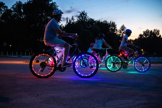a family riding their bikes with LED lights on the wheels
