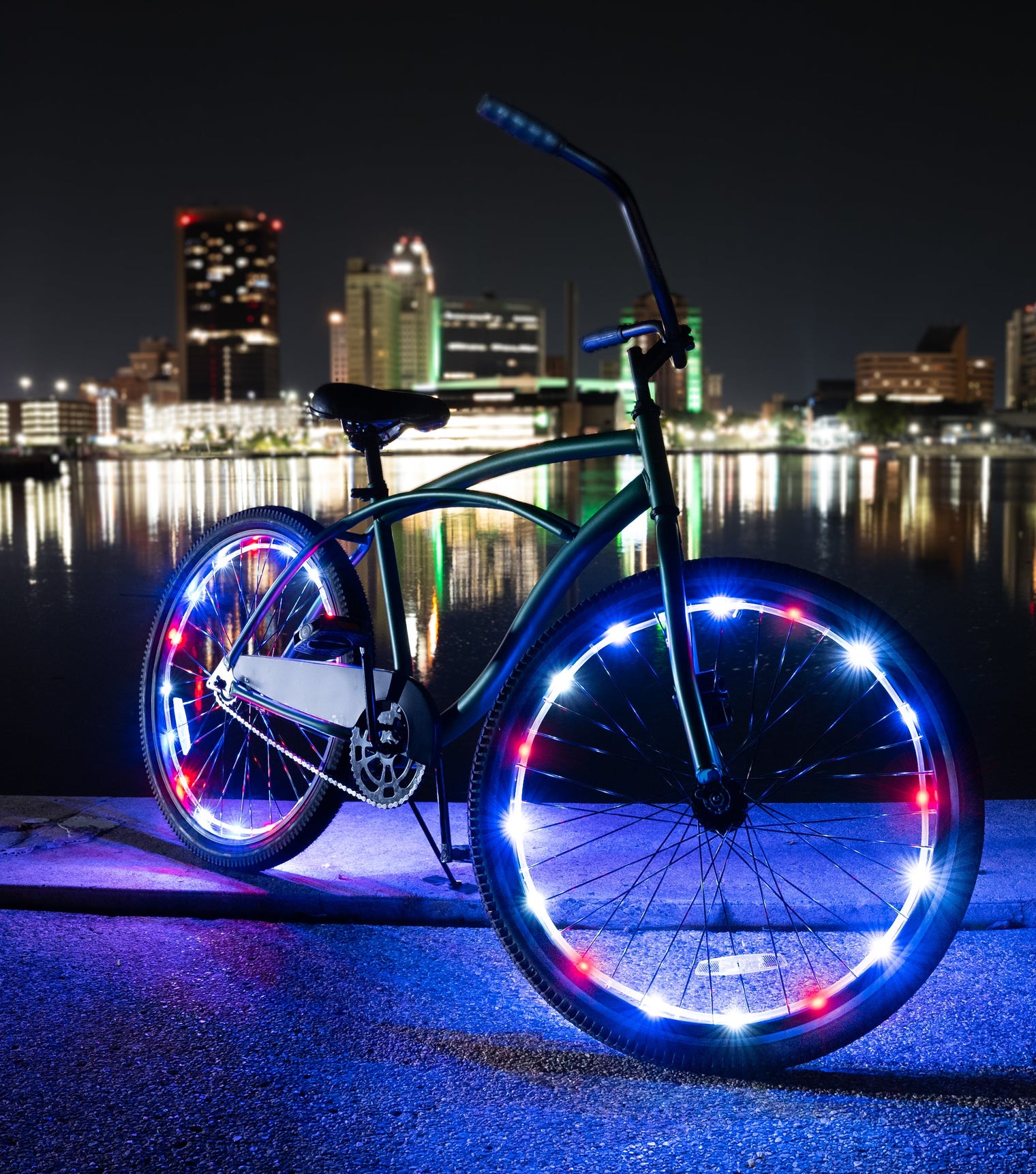 Bicycle with patriotic LED wheel lights by a waterfront at night