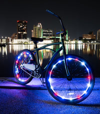 Bicycle with patriotic LED wheel lights by a waterfront at night