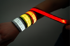 Glowing multicolored LED wristbands on a dark background